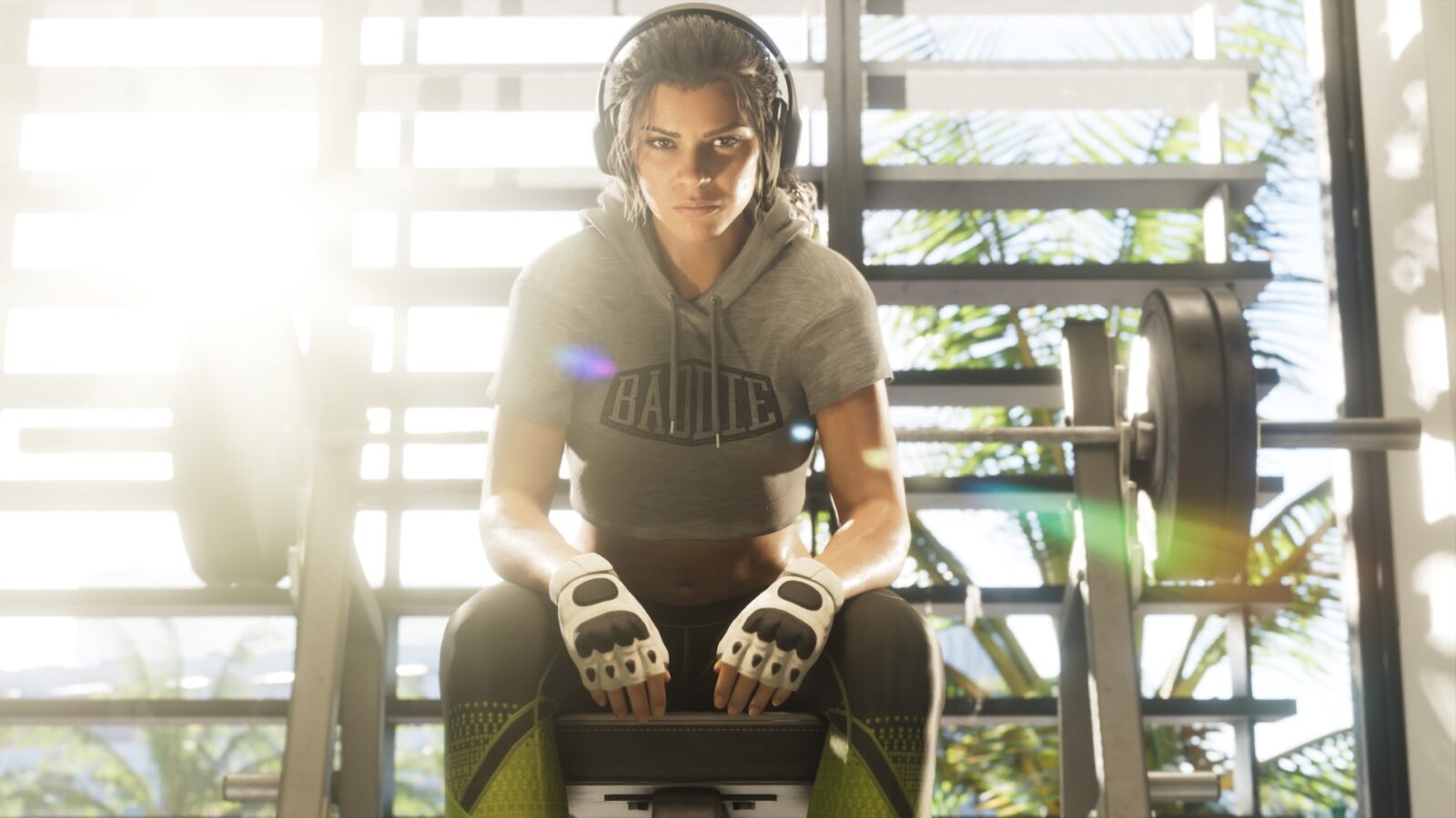 Official Grand Theft Auto VI image of Lucia Caminos sitting on a gym bench wearing headphones and fingerless gloves