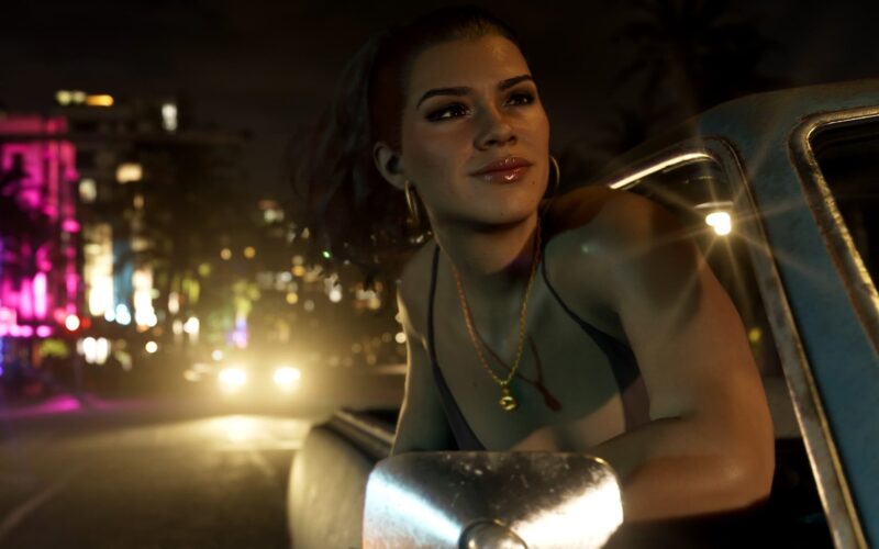 Official Grand Theft Auto VI image of Lucia leaning out of a car window on a neon-lit street at night