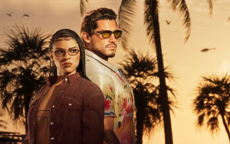 Official Grand Theft Auto VI image of Lucia and Jason standing back to back in front of palm trees at sunset